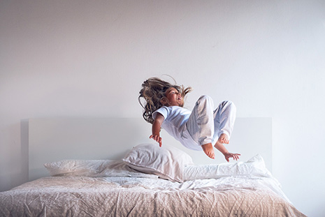 Girl jumping on bed enjoying fresh air in Belleview FL